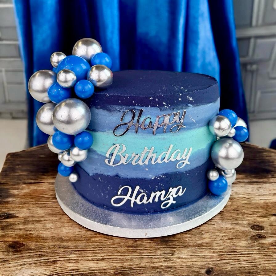 Blue birthday cake with silver spheres